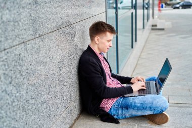 Açık havada üniversite kampüsü içinde oturan ve laptop ile çalışma, sınavlara hazırlık, yazarak, internet'te sörf, dinlenme, kopya alanı öğrenci. Teknoloji, eğitim kavramı