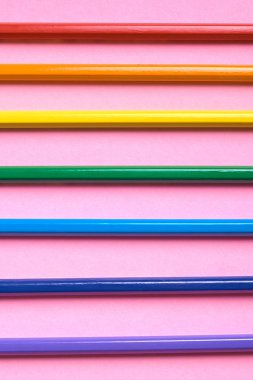 Kalemler üzerinde pastel pembe renk, yakın çekim. Renkli kalemler ayarla, alanı Kopyala. Boya kalemi. Üstten görünüm, düz yatıyordu. Gökkuşağı. Okul hazırlıkları kavramı kolej. Arka plan