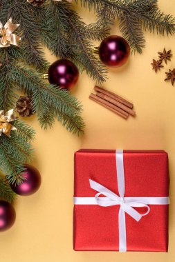 Noel arka plan kırmızı hediye kutusu, köknar ağacı dalları ile cam topları, çam kozalakları, tarçın ve Yıldız anason altın arka plan üzerinde boş alan. Kopya alanı düz yatıyordu, en iyi manzaralı 