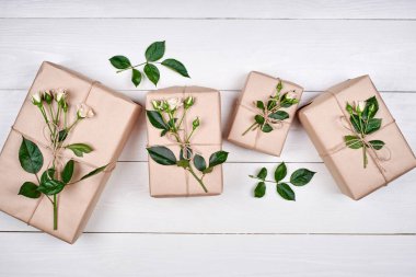 Taze gül ahşap masa, kopya alanı üzerinde dalları ile hediye kutuları. Tatil arka plan, satış, alışveriş. Hediye. Tebrik kartı Womans gün, Sevgililer günü, anneler günü, düz için lay