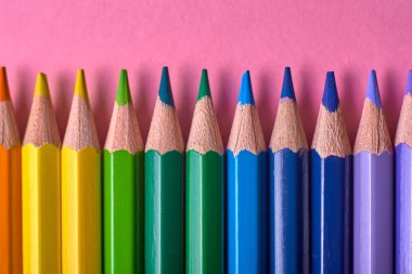 Kalemler üzerinde pastel pembe renk, yakın çekim. Renkli kalemler ayarla, alanı Kopyala. Boya kalemi. Üstten görünüm, düz yatıyordu. Okul hazırlıkları kavramı kolej. Arka plan
