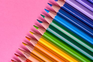 Kalemler üzerinde pastel pembe renk, yakın çekim. Renkli kalemler ayarla, alanı Kopyala. Boya kalemi. Üstten görünüm, düz yatıyordu. Okul hazırlıkları kavramı kolej. Arka plan