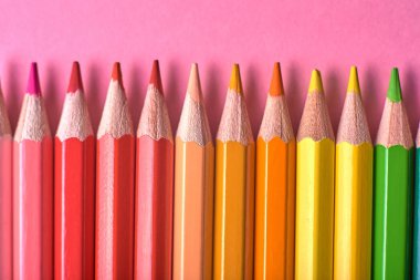 Kalemler üzerinde pastel pembe renk, yakın çekim. Renkli kalemler ayarla, alanı Kopyala. Boya kalemi. Üstten görünüm, düz yatıyordu. Okul hazırlıkları kavramı kolej. Arka plan