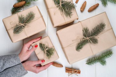 Noel hediye ambalaj arka plan, kopya alanı. Noel hediyesi kutu tutan eller kraft, üstten görünüm tamamladı. Kış tatil kavramı, düz yatıyordu. Kadın kırmızı manikür Noel hediye ambalaj ile