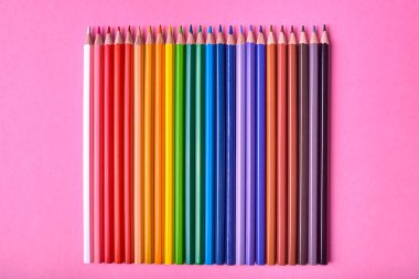 Kalemler üzerinde pastel pembe renk, yakın çekim. Renkli kalemler ayarla, alanı Kopyala. Boya kalemi. Üstten görünüm, düz yatıyordu. Okul hazırlıkları kavramı kolej. Arka plan