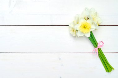 Beyaz ahşap zemin, kopya alanı üzerine Nergis çiçek buket. Üstten görünüm, düz yatıyordu. Beyaz nergis. Bahar çiçekleri. Tebrik kartı için 8 Mart (kadınlar günü), anneler günü. Paskalya arka plan bahar