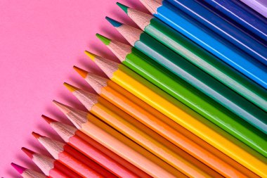 Kalemler üzerinde pastel pembe renk, yakın çekim. Renkli kalemler ayarla, alanı Kopyala. Boya kalemi. Üstten görünüm, düz yatıyordu. Okul hazırlıkları kavramı kolej. Arka plan