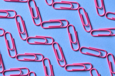 Kağıt üzerinde mavi arka plan izole klip pembe, yakın çekim, uzay kopyalayın. Üstten görünüm, düz yatıyordu. Okul, Kolej, eğitim kavramı hazırlıkları