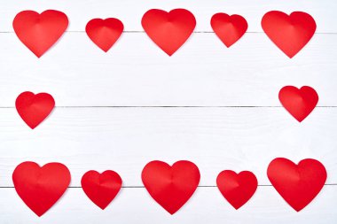 Çerçeve beyaz ahşap arka plan, metin için kopya yer kırmızı kağıt kalpler yapılmıştır. Tebrik kartı mockup Saint Sevgililer günü için. Üstten görünüm, düz yatıyordu. Aşk, boş alan sembolü. Aşk kavramı düğün,
