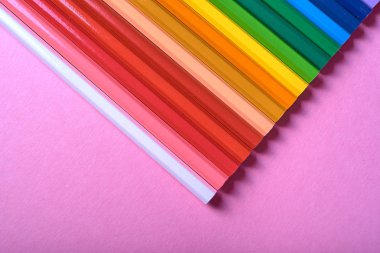 Kalemler üzerinde pastel pembe renk, yakın çekim. Renkli kalemler ayarla, alanı Kopyala. Boya kalemi. Üstten görünüm, düz yatıyordu. Okul hazırlıkları kavramı kolej. Arka plan