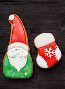 Üstten görünüm, koyu ahşap masa üzerine krema ile lezzetli ev yapımı gingerbread çerezleri lay düz. Noel Noel Baba ve çorap, kopya alanı arka plan. Tatil Gıda