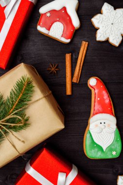 Noel gingerbread çerezleri, Kraft kağıt köknar ağacı dalı ve koyu ahşap zemin, üzerine tarçın ile sarılmış hediye kutusu alanı kopyalayın. Üstten görünüm, düz yatıyordu