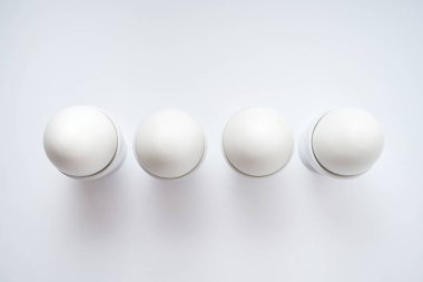 Beyaz yumurta beyaz arka plan üzerinde kopya alanı izole yumurtalık tutuyoruz. Satır standında haşlanmış yumurta. Üstten görünüm, düz yatıyordu. Sağlıklı gıda kavramı 