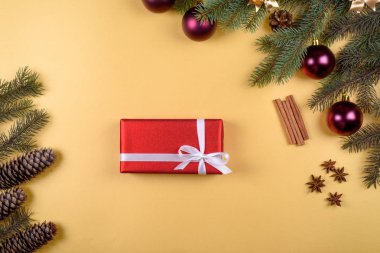 Noel arka plan kırmızı hediye kutusu, köknar ağacı dalları ile cam topları, çam kozalakları, tarçın ve Yıldız anason altın arka plan üzerinde boş alan. Kopya alanı düz yatıyordu, en iyi manzaralı 