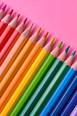 Kalemler üzerinde pastel pembe renk, yakın çekim. Renkli kalemler ayarla, alanı Kopyala. Boya kalemi. Üstten görünüm, düz yatıyordu. Okul hazırlıkları kavramı kolej. Arka plan