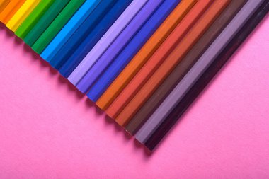 Kalemler üzerinde pastel pembe renk, yakın çekim. Renkli kalemler ayarla, alanı Kopyala. Boya kalemi. Üstten görünüm, düz yatıyordu. Okul hazırlıkları kavramı kolej. Arka plan