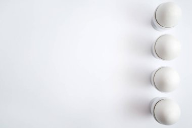 Beyaz yumurta beyaz arka plan üzerinde kopya alanı izole yumurtalık tutuyoruz. Satır standında haşlanmış yumurta. Üstten görünüm, düz yatıyordu. Sağlıklı gıda kavramı 