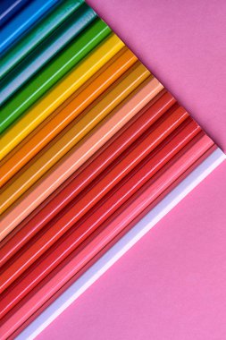 Kalemler üzerinde pastel pembe renk, yakın çekim. Renkli kalemler ayarla, alanı Kopyala. Boya kalemi. Üstten görünüm, düz yatıyordu. Okul hazırlıkları kavramı kolej. Arka plan