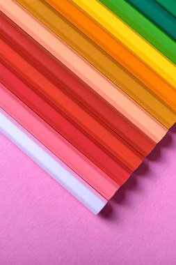 Kalemler üzerinde pastel pembe renk, yakın çekim. Renkli kalemler ayarla, alanı Kopyala. Boya kalemi. Üstten görünüm, düz yatıyordu. Okul hazırlıkları kavramı kolej. Arka plan