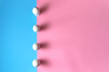 Beyaz yumurta yumurtalık mavi ve pembe pastel arka plan, kopya alanı üzerinde tutuyoruz. Satır standında iki tonu renk kağıt zemin üzerine haşlanmış yumurta. Sağlıklı gıda kavramı. Paskalya yumurtaları. Flatlay, üstten görünüm