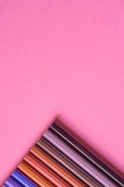 Kalemler üzerinde pastel pembe renk, yakın çekim. Renkli kalemler ayarla, alanı Kopyala. Boya kalemi. Üstten görünüm, düz yatıyordu. Okul hazırlıkları kavramı kolej. Arka plan
