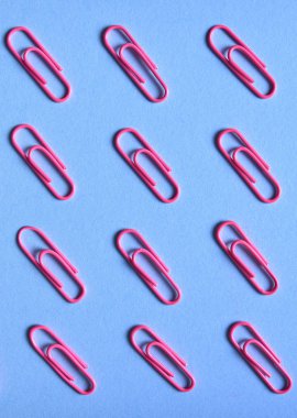 Kağıt üzerinde mavi arka plan izole klip pembe, yakın çekim, uzay kopyalayın. Üstten görünüm, düz yatıyordu. Okul, Kolej, eğitim kavramı hazırlıkları
