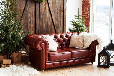 Ahşap kapı ve panoramik pencere, kopya alanı ile çatı odasında deri vintage kahverengi chesterfield kanepe Noel iç çam ağacı ve hediye kutuları