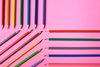 Kalemler üzerinde pastel pembe renk, yakın çekim. Renkli kalemler ayarla, alanı Kopyala. Boya kalemi. Üstten görünüm, düz yatıyordu. Okul hazırlıkları kavramı kolej. Arka plan