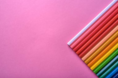 Kalemler üzerinde pastel pembe renk, yakın çekim. Renkli kalemler ayarla, alanı Kopyala. Boya kalemi. Üstten görünüm, düz yatıyordu. Okul hazırlıkları kavramı kolej. Arka plan