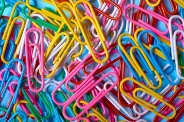 Renkli ataç arka plan kopya alanı. Üstten görünüm. Okul, üniversite, iş kavramı hazırlıkları. Beyaz, pembe, mavi, kırmızı, sarı, yeşil ataç yığını. Arka plan