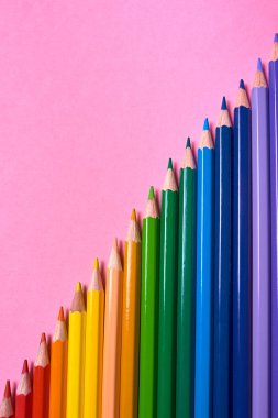 Kalemler üzerinde pastel pembe renk, yakın çekim. Renkli kalemler ayarla, alanı Kopyala. Boya kalemi. Üstten görünüm, düz yatıyordu. Okul hazırlıkları kavramı kolej. Arka plan
