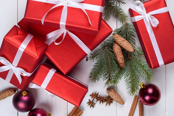 Weihnachtlicher Hintergrund Mit Roten Geschenkboxen Tannenzweigen Tannenzapfen Glaskugeln Zimtstangen Und — Stockfoto
