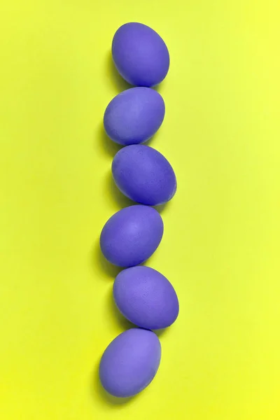 Rij Van Geschilderde Violet Pasen Eieren Gele Achtergrond Kopie Ruimte — Stockfoto