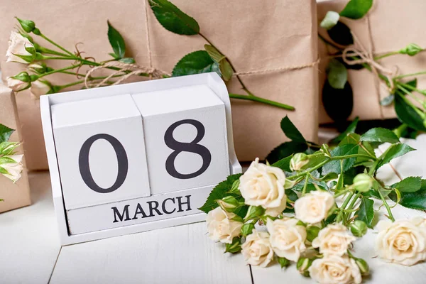 木製キューブ カレンダー ギフト ボックス クラフト 白いテーブルに新鮮なパステル調のバラに包まれて 日の日付を保存します 日女性の日のホリデー グリーティング カード — ストック写真