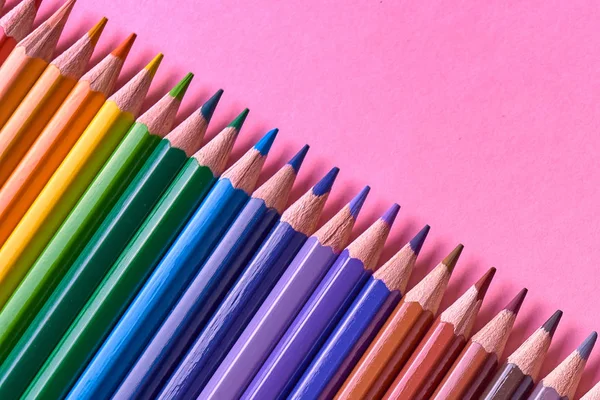 Kalemler üzerinde pastel pembe renk, yakın çekim. Renkli kalemler ayarla, alanı Kopyala. Boya kalemi. Üstten görünüm, düz yatıyordu. Okul hazırlıkları kavramı kolej. Arka plan