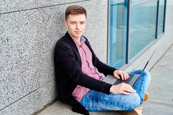 Açık havada üniversite kampüsü içinde oturan ve laptop ile çalışma, sınavlara hazırlık, yazarak, internet'te sörf, dinlenme, kopya alanı öğrenci. Teknoloji, eğitim kavramı