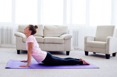 Pratik yoga adlı genç bir kadın portresi kapalı ev, uzay kopyalayın. Kobra poz, tam uzunlukta pratik kız. Rahatlatıcı ve yoga yapıyordum. Sağlık ve sağlıklı yaşam tarzı. Bhujangasana