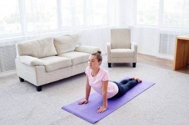 Pratik yoga adlı genç bir kadın portresi kapalı ev, uzay kopyalayın. Kobra poz, tam uzunlukta pratik kız. Rahatlatıcı ve yoga yapıyordum. Sağlık ve sağlıklı yaşam tarzı. Bhujangasana