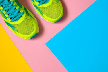 Çift spor ayakkabı renkli arka plan üzerinde. Pembe, mavi ve sarı arka plan, kopya alanı üzerinde yeni spor ayakkabıları. Genel gider atış koşu ayakkabıları. Üstten görünüm, düz yatıyordu