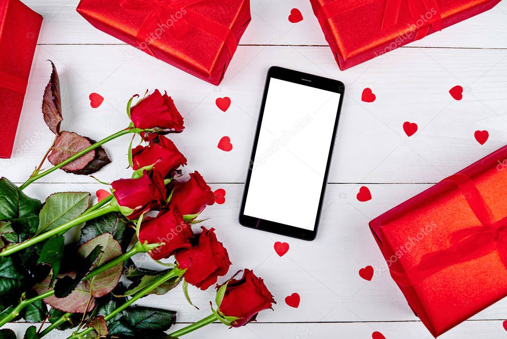 Bouquet of roses, red gift boxes, paper hearts and cellphone with blank screen on white background, copy space. Valentines day, Womens Day, Mothers Day. Top view, flat lay