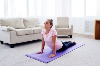 Pratik yoga adlı genç bir kadın portresi kapalı ev, uzay kopyalayın. Kobra poz, tam uzunlukta pratik kız. Rahatlatıcı ve yoga yapıyordum. Sağlık ve sağlıklı yaşam tarzı. Bhujangasana