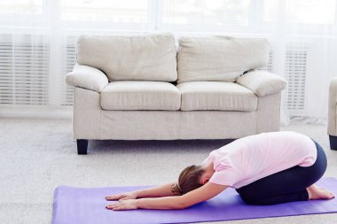 Genç kadın kopya alanı kapalı, evde yoga pratik portresi. Kız meditasyon çocuğun poz, tam uzunlukta sakin ol. Dinlenme, germe, rahatlatıcı ve yapıyor yoga. Sağlık ve sağlıklı yaşam tarzı