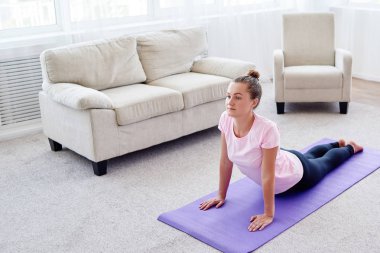 Pratik yoga adlı genç bir kadın portresi kapalı ev, uzay kopyalayın. Kobra poz, tam uzunlukta pratik kız. Rahatlatıcı ve yoga yapıyordum. Sağlık ve sağlıklı yaşam tarzı. Bhujangasana