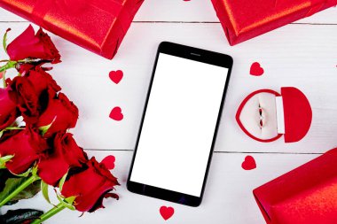 Boş ekran, güller, kırmızı hediye kutuları, altın yüzük kutusu ve beyaz arka plan, kopya alanı kalpler buket ile cep telefonu kapatın. Sevgililer günü, Bayan gün. Aşk kavramı. Üstten görünüm, düz yatıyordu