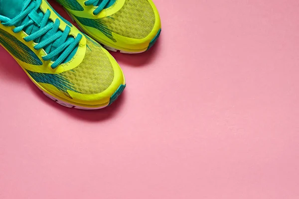 Pair of new sport shoes isolated on pink pastel background. New sneakers. Overhead shot of running foot wear. Sport, healthy lifestyle, minimal concept.Top view, flat lay