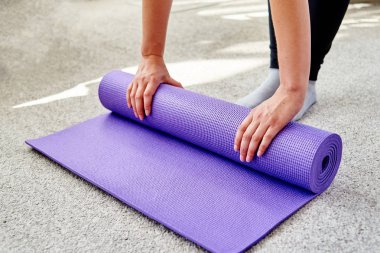 Spor uygulama, pilates ya da evde veya Studio çalışma dışarı sonra mor fitness ya da yoga mat haddeleme kadın görüntüsünü kapatmak