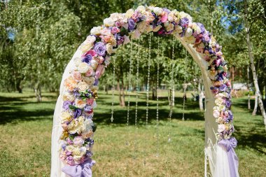 Güzel düğün kemer kopya alanı beyaz, pembe ve mor çiçekler, kristaller ve bahçede açık havada, bez ile dekore edilmiştir. Düğün Kur. Tören için bir yer. Çiçek kompozisyon