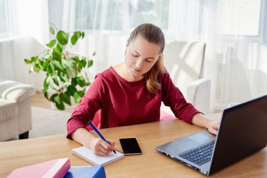 Notepat yazma ve modern ofis, kopya alanı dizüstü bilgisayar kullanan ahşap masa başında oturan genç iş kadını portresi