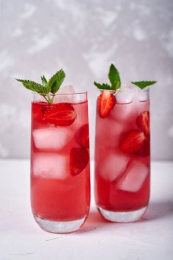 Gri masa arka plan üzerinde cam buz ve nane ile taze çilek limonata, kopya alanı. Soğuk yaz içkisi. Berry kokteyl ile Köpüklü gözlük