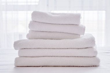 Modern otelde yatak çarşafı üzerinde beyaz temiz banyo havlusu Yığını olmak